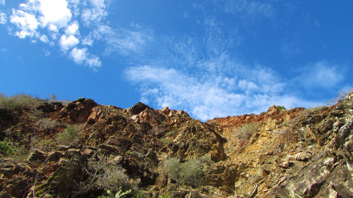 Low angle view of mountain against blue sky