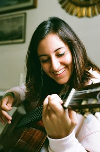 Portrait of smiling young woman holding camera