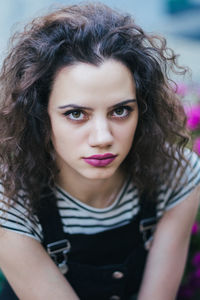 Portrait of beautiful young woman sitting outdoors