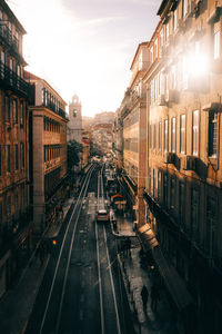 Railroad tracks amidst buildings in city against sky