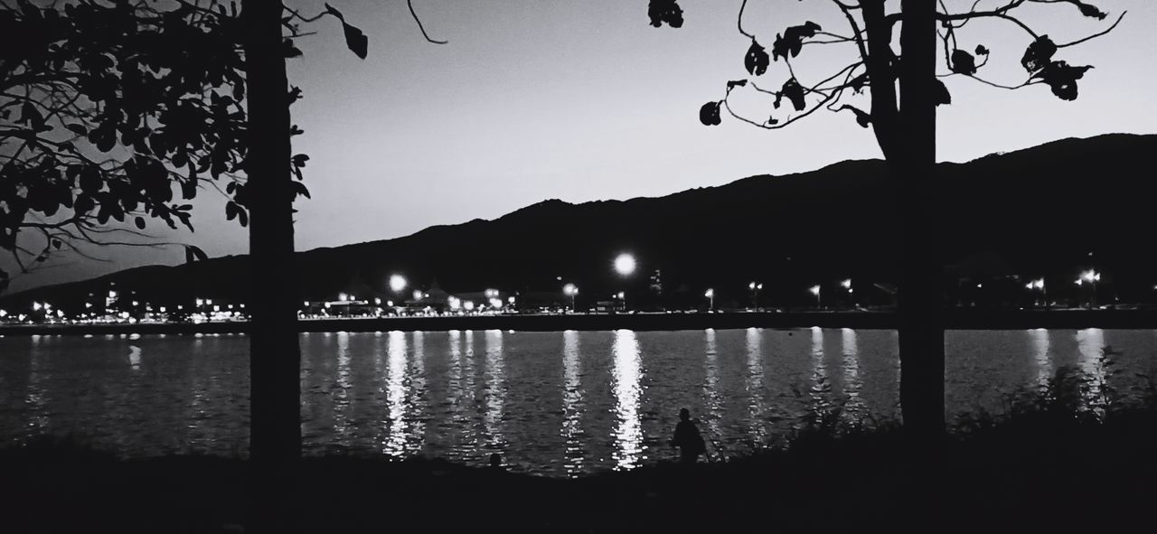 SILHOUETTE TREE BY LAKE AGAINST SKY AT NIGHT