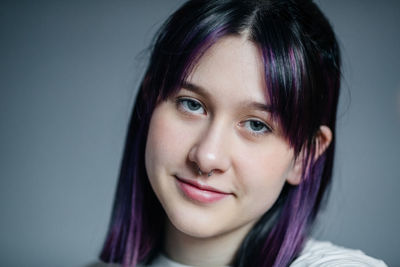 Portrait of a smiling young girl with purple hair close-up