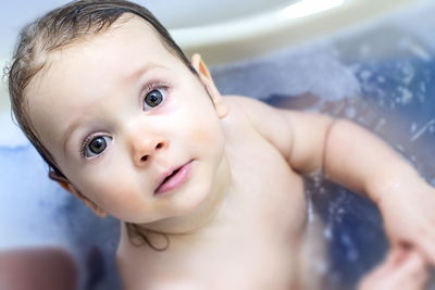 Portrait of cute baby boy in bathroom