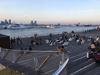 High angle view of people in city by sea against sky