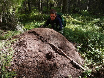 Woman by anthill at forest