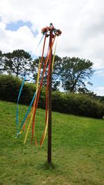 Traditional windmill hanging on field against sky