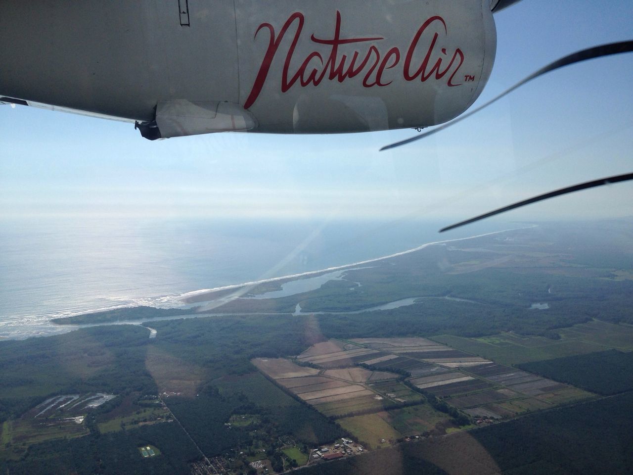 aerial view, flying, air vehicle, airplane, aircraft wing, transportation, sky, sea, mid-air, travel, landscape, mode of transport, part of, scenics, cloud - sky, cropped, beauty in nature, nature, mountain, water