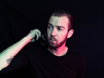 Man looking away against black background