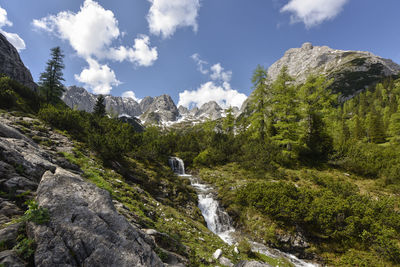 Scenic view of waterfall against sky