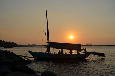 Silhouette boats in sea against sky during sunset