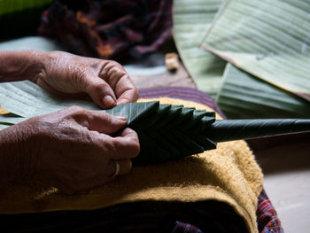 Midsection of person making leaf decoration