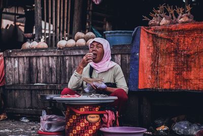 Portrait of smiling woman sitting at market