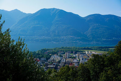 Aerial view of townscape and mountains against sky