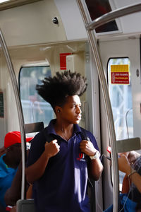 Full length of man looking through train window