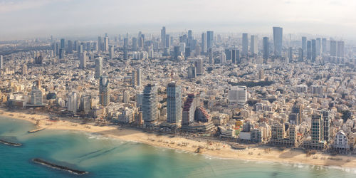 High angle view of buildings by sea against sky