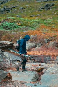 Rear view of man standing on rock