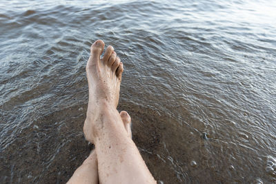 Low section of man relaxing in sea