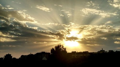 Silhouette cityscape against sky during sunset