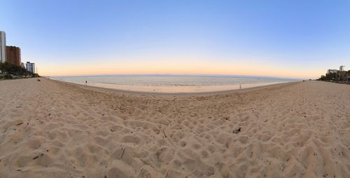 Scenic view of beach against clear sky during sunset