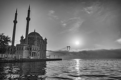 View of buildings at waterfront against cloudy sky and fog