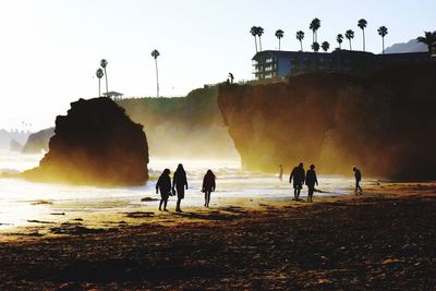 People at beach against sky