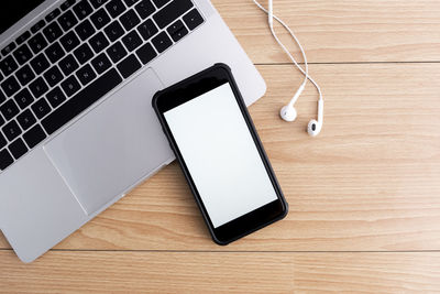 Top view of designer workplace with mock up smartphone on table.