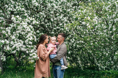 Family mom mom baby daughter in the garden blooming apple trees