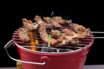 Close-up of food on barbecue grill against black background