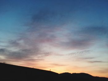 Low angle view of silhouette mountain against dramatic sky