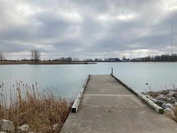 Pier over lake against sky