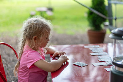Side view of a girl looking at table