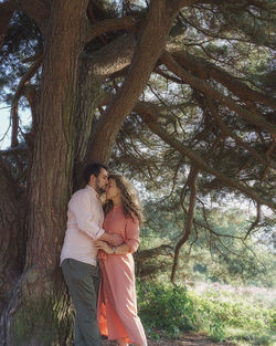Rear view of couple standing against trees