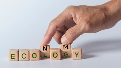 Hand with toy on table against white background