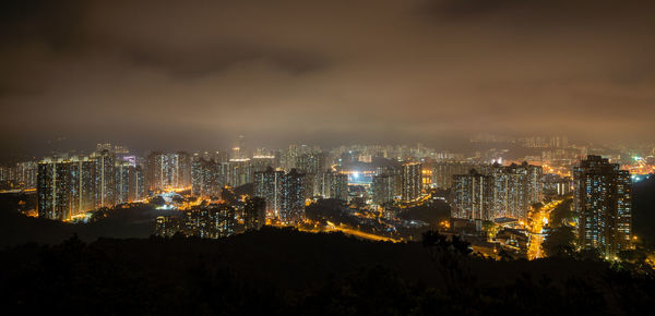 High angle view of illuminated buildings against sky at night