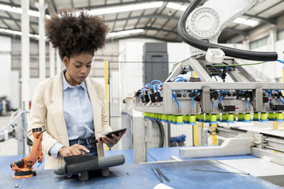 Businesswoman holding tablet pc working in factory