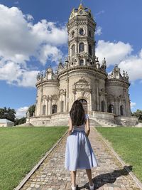 Rear view of woman walking in temple against building