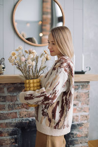 Side view of woman standing against wall