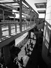 High angle view of people walking on street below bridge