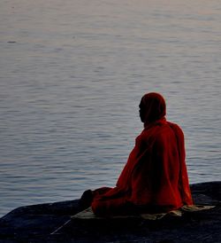 Mature man sitting by sea 