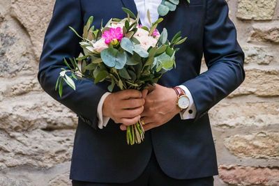 Midsection of man holding flower