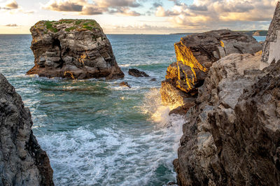 Rock formation in sea against sky