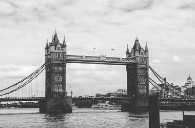 Bridge over river against clouds