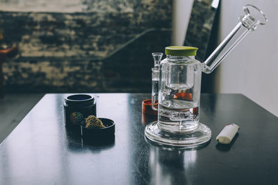 Close-up of water bong and marijuana on table
