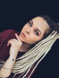 Portrait of beautiful woman against black background