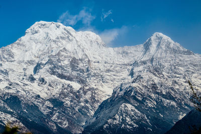 Scenic view of snowcapped mountains against blue sky