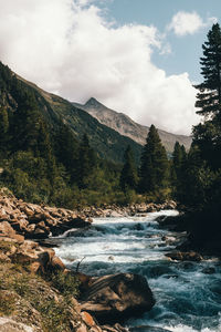 Scenic view of river amidst mountains against sky