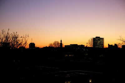View of buildings against clear sky at sunset