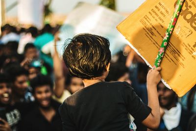 Rear view of girl holding banner during protest