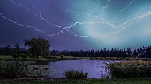 Lightning over lake against sky at night