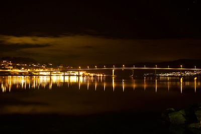 Scenic view of illuminated sea against sky at night